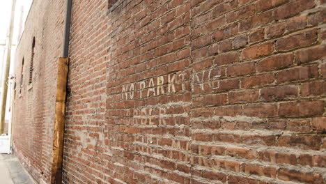 pared de ladrillo pintada con señal de estacionamiento prohibido primer plano desde la derecha