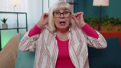 senior old grandmother making silly facial expressions and grimacing, fooling around, showing tongue