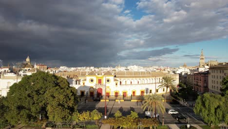 aerial rise through trees reveals spain seville sprawling cityscape and storm cloud