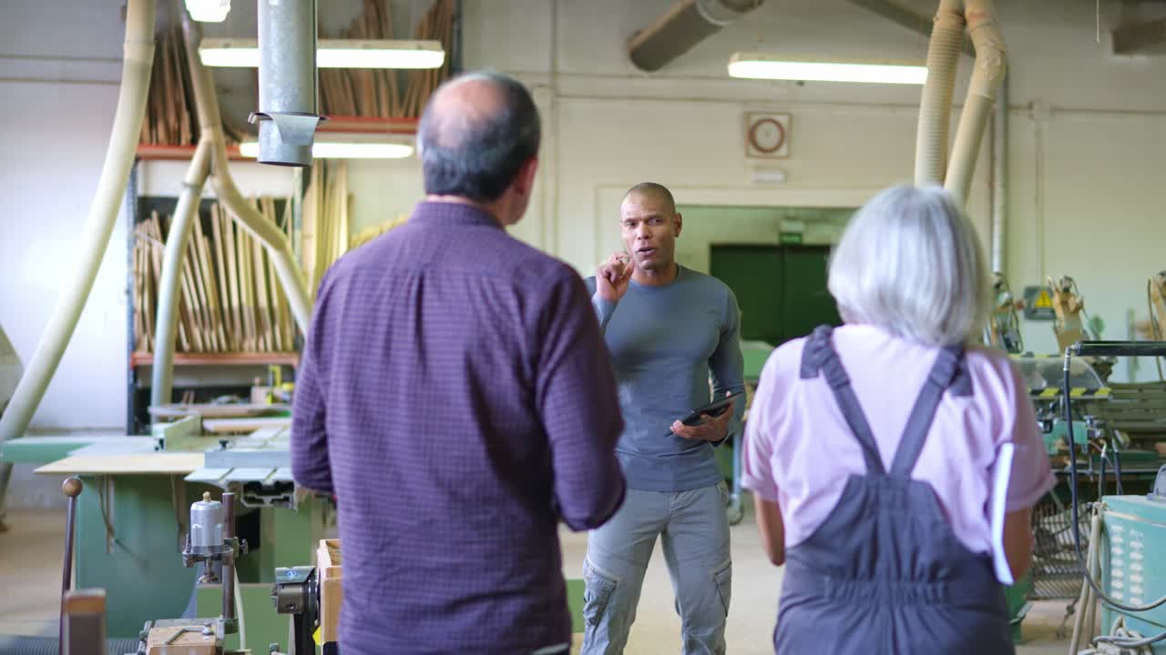 Team of Workers Discussing in a Woodworking Workshop