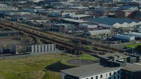 Aerial-tracking-shot-of-tram-traveling-over-rails-in-Edinburgh-as-it-travels-off-into-the-distance