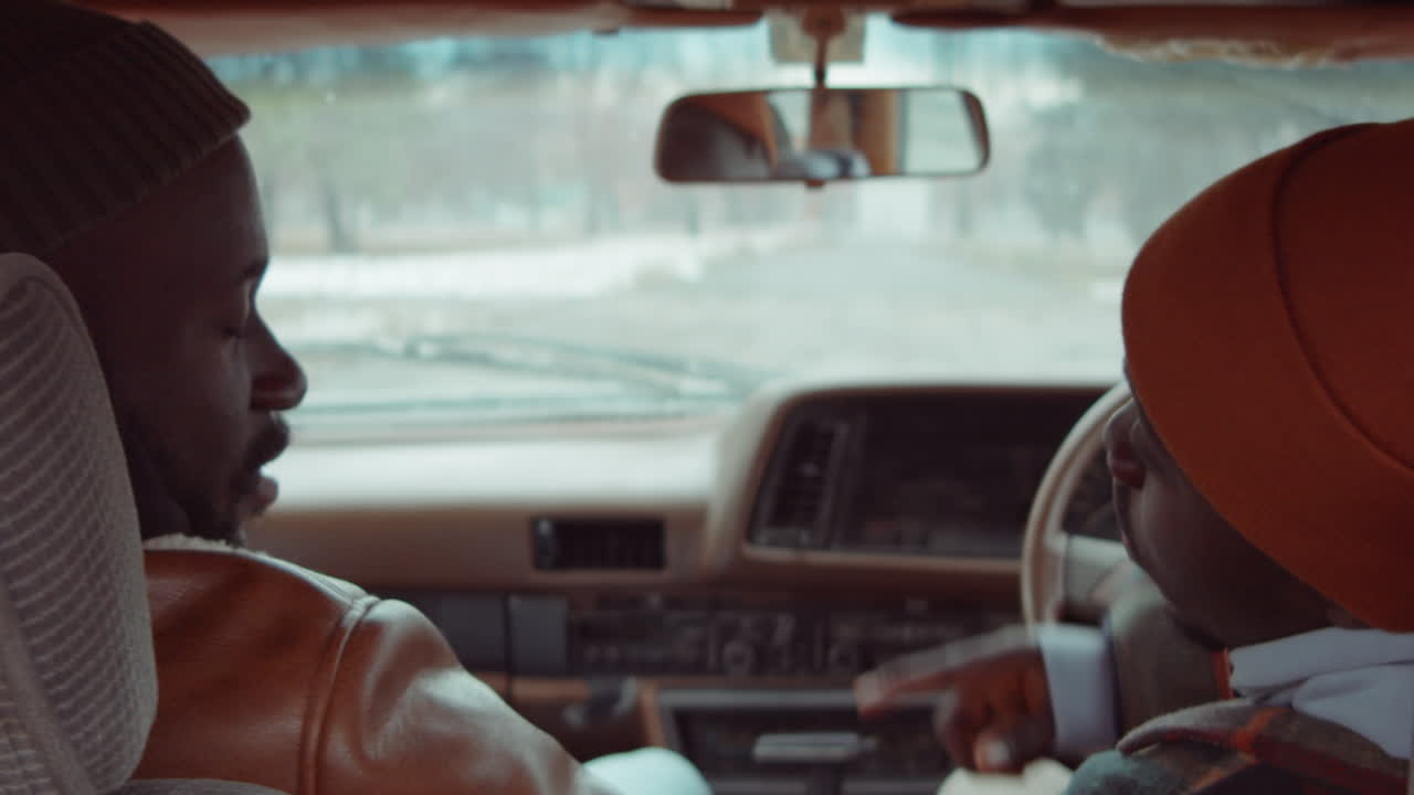 dos hombres afroamericanos hablando en el coche