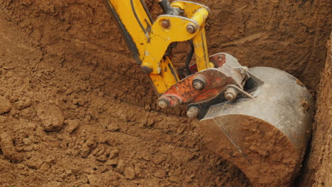 un cubo de excavadora grande extrae suelo del trabajo de excavación en un sitio de construcción