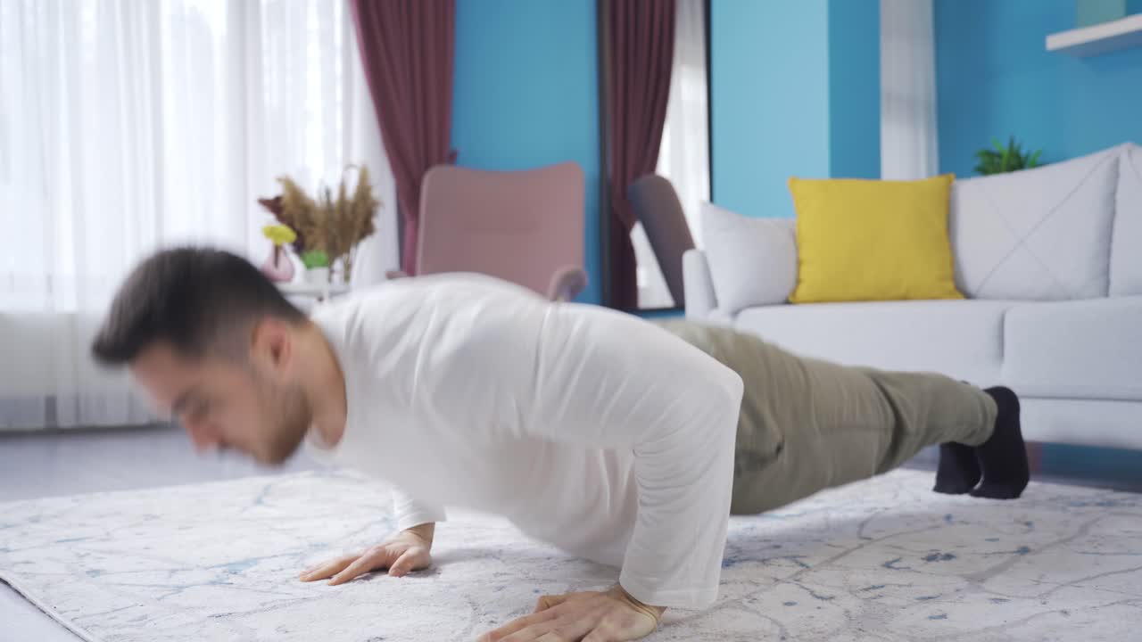 운동선수, 근육질의 젊은이가 집에서 부시를 하고 있습니다. 집에서 운동을 합니다.