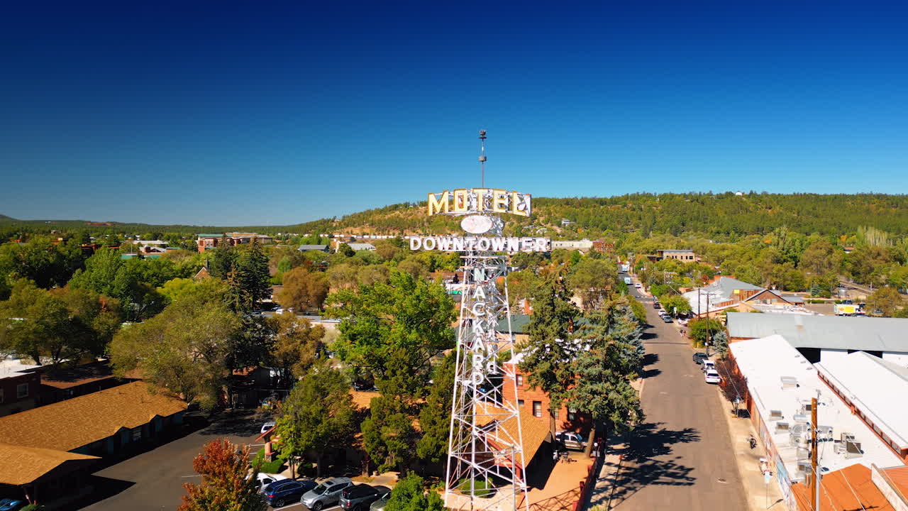 Flagstaff, USA, 24 August 2025: Tower of a motel with a signboard in Flagstaff, Arizona, USA. Aerial perspective on the green sunny city from drone