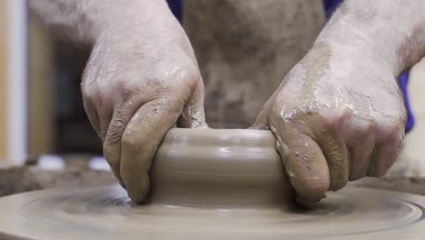 pottery artist shaping clay on a wheel