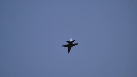 f-18 fighter jet performs an aileron roll with afterburner during the nightfall solo display at abbotsford airshow track