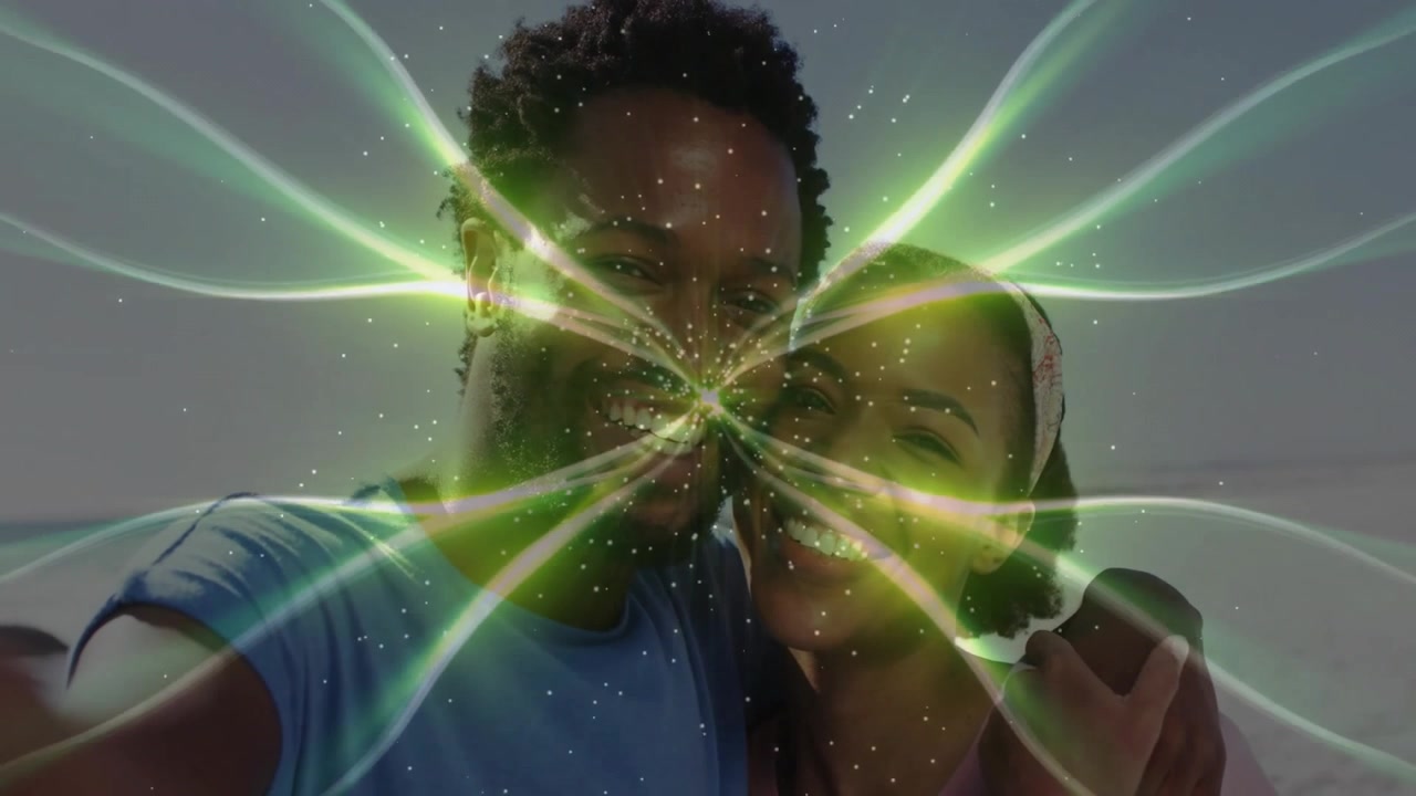 Casal segurando smartphone na costa tirando uma selfie e feixes fractais verdes pulsando, representando tecnologia.