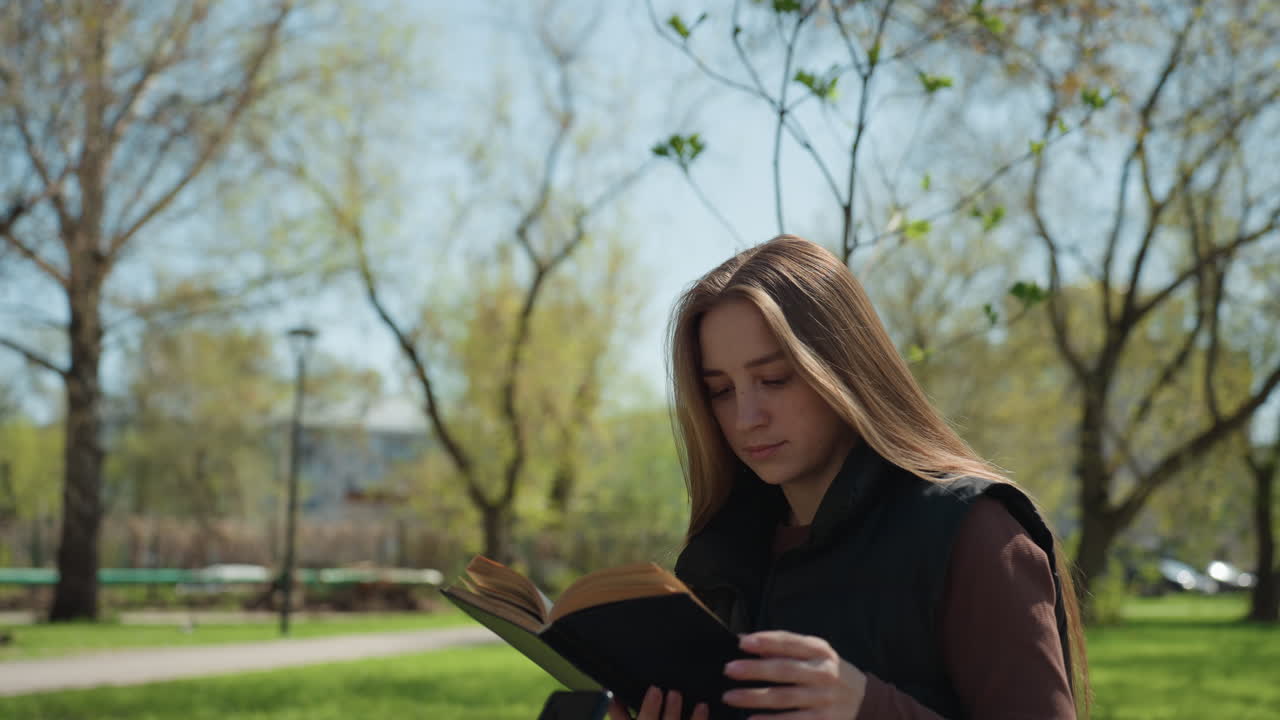 Une femme assise dans un parc, plongée dans ses pensées, une jeune femme d’origine européenne réfléchissant au milieu d’un cadre naturel, une femme caucasienne profitant d’un moment de tranquillité pour écrire et s’introspecter à l’extérieur.