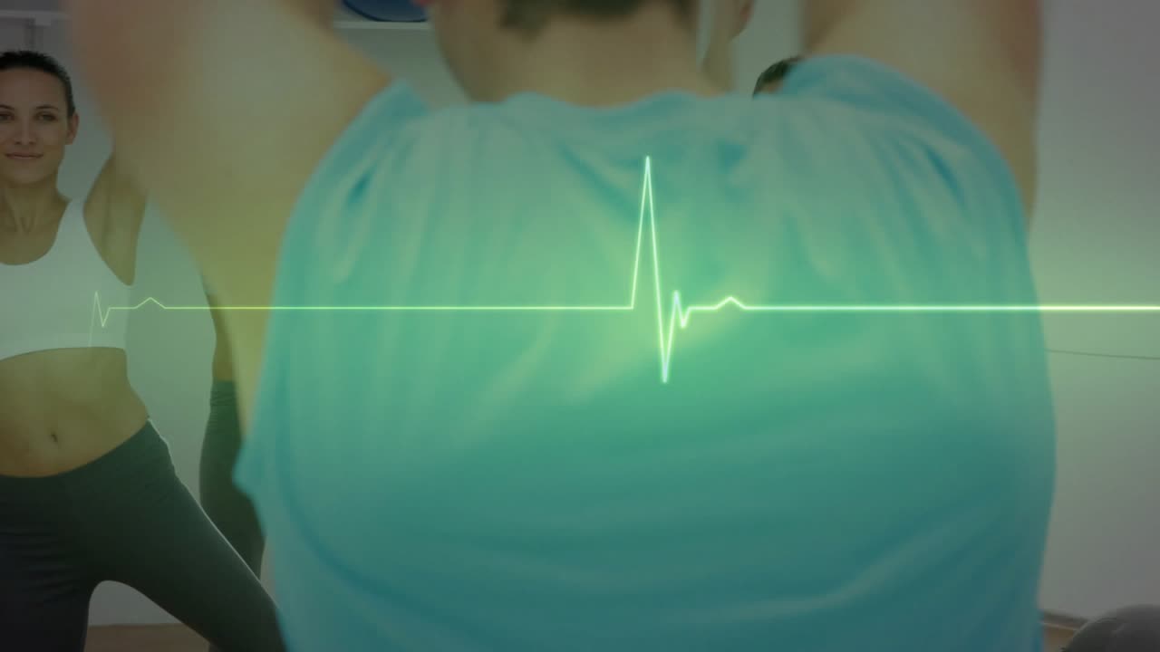 Male instructor raising arms cueing fitness class, women mirroring, ECG pulsing, raising heart rate