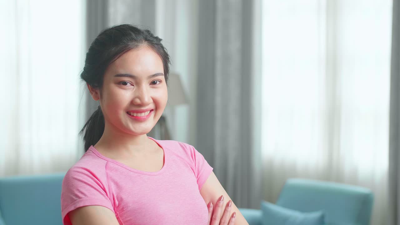 Asian Beautiful Girl In Sportswear Is Posing With A Soft Smile In Her Living Room