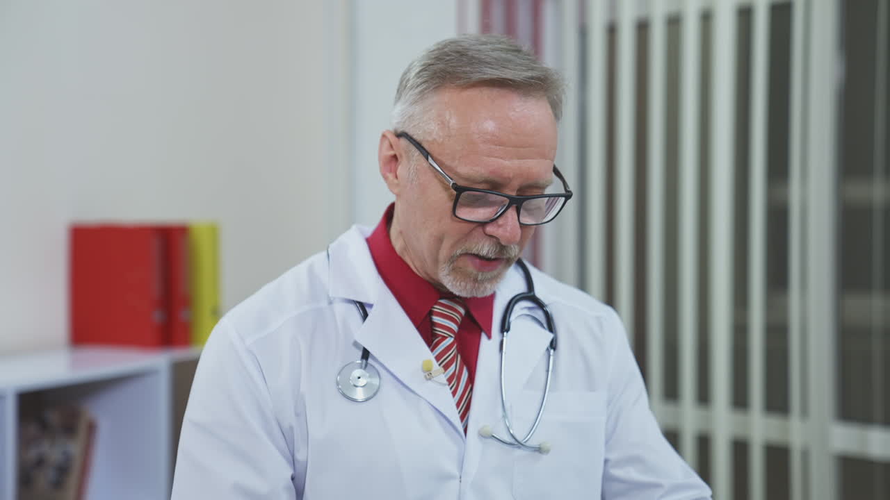 Senior doctor talking to camera. Talking doctor during online video chat with patient
