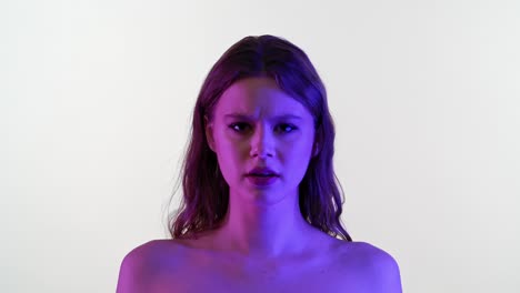 portrait of a young woman with changing expressions under neon lighting