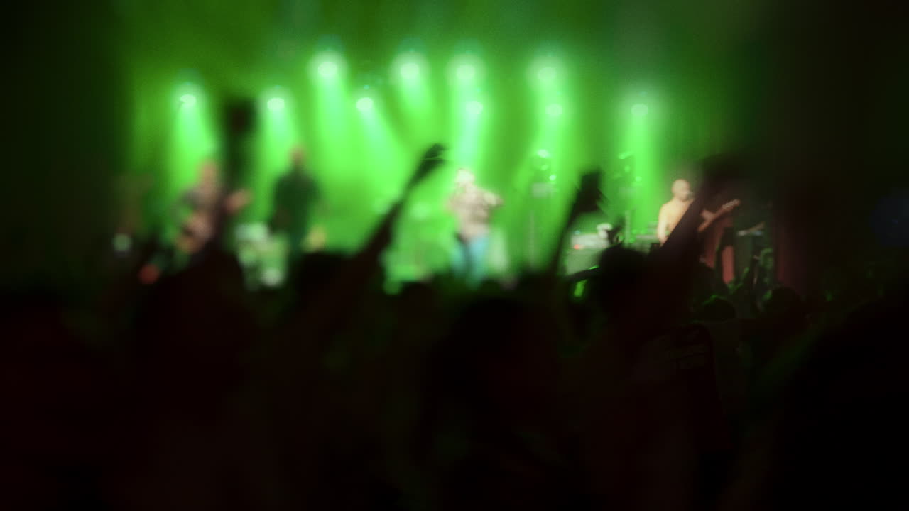 Folla energica a un concerto dal vivo con luci vibranti e un'atmosfera dinamica che crea eccitazione