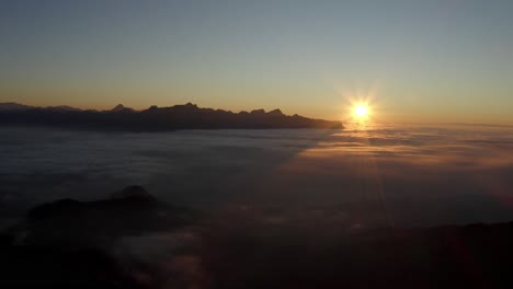 high flight above fog at sunset, the alps in the background - switzerland