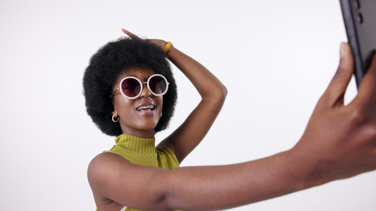 Donna elegante con capelli afro che si scatta un selfie