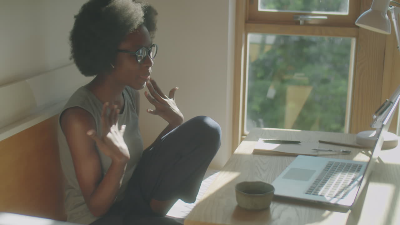 African American Woman Video Calling on Laptop at Home