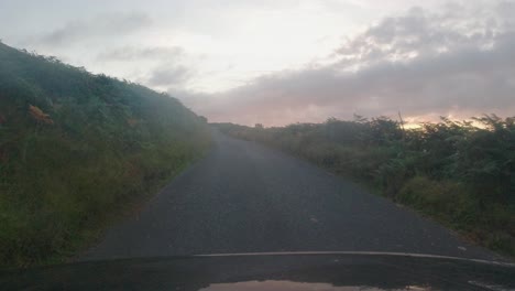 driving on countryside road with sunset on horizon with dramatic clouds and green moorland in north devon uk 4k
