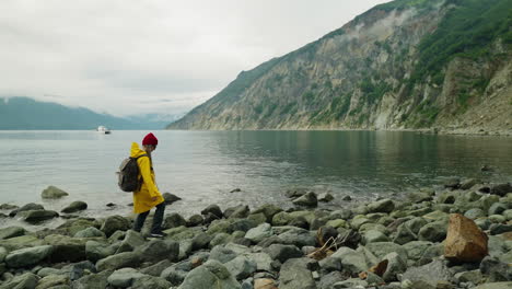 person hiking along a rocky coastline in rainy weather