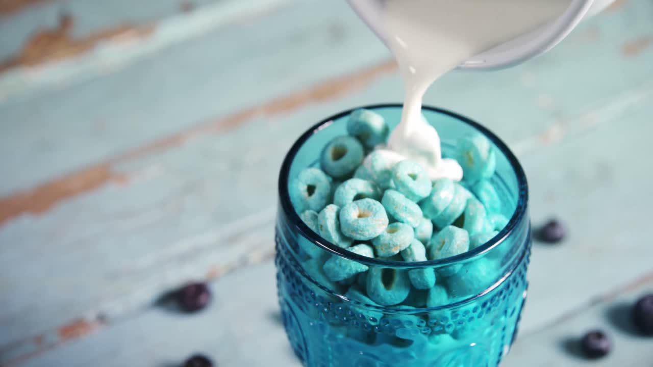 우유는 시리얼 링 4k의 유리잔에 부어집니다.