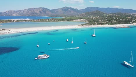 boat sails to porto giunco beach in villasimius, sardinia, italy - aerial 4k circling