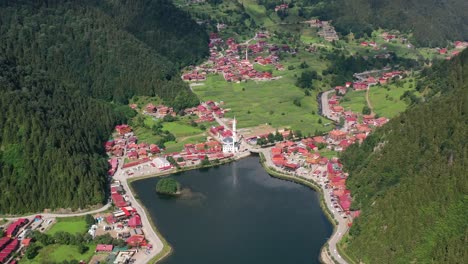 Drone-Aéreo-De-Un-Lago-Rodeado-Por-Un-Pequeño-Pueblo-De-Montaña-En-Uzungol-Trabzon-En-Un-Día-Soleado-De-Verano-En-Turquía