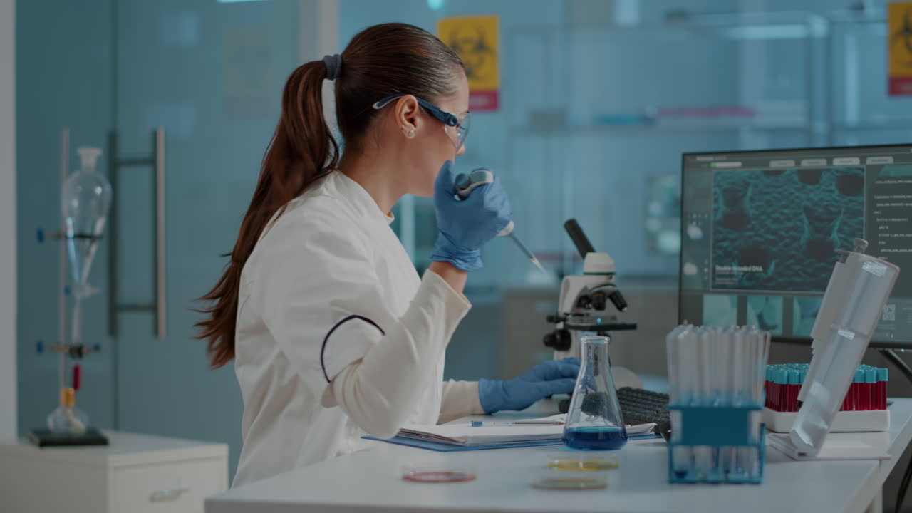 Woman biologist using micro pipette with test tube and beaker