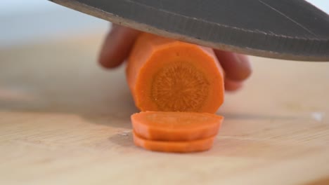 Extreme-close-up-of-Woman's-hand-cutting-a-carrot