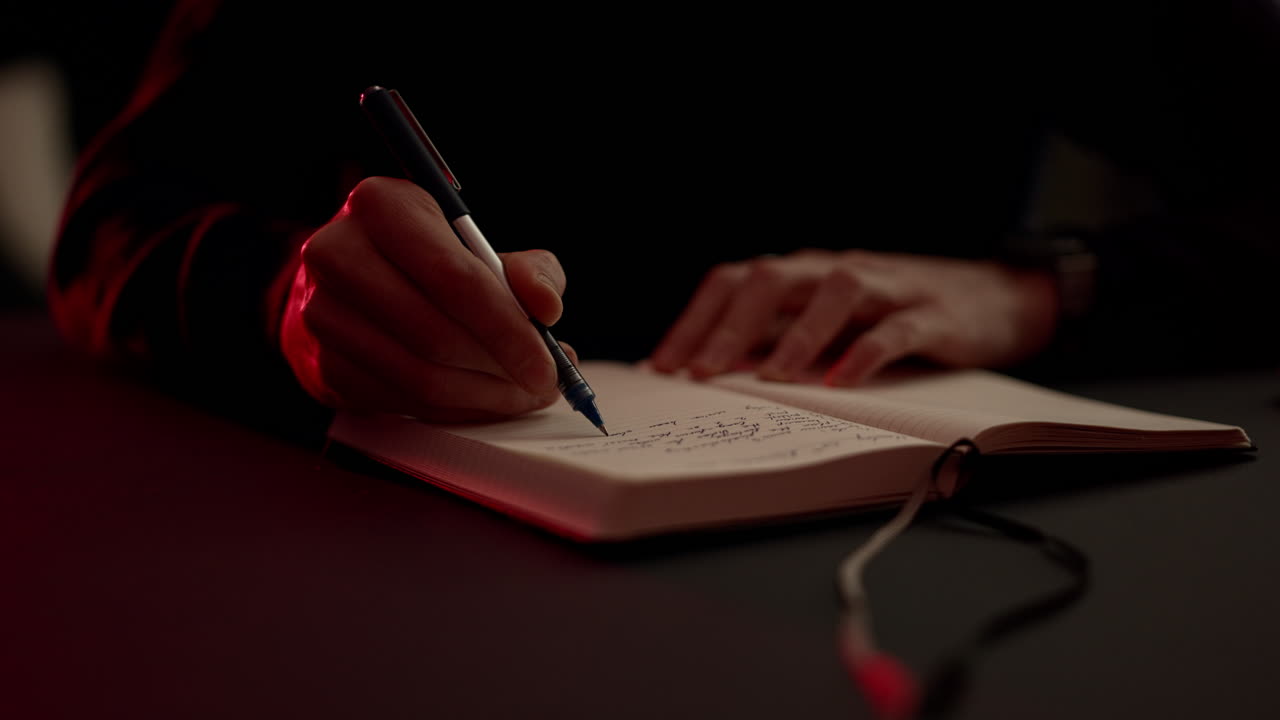 A person writing, journaling in a notebook with a pen, creating a calm journaling moment. Cozy warm light and cinematic tones highlight personal reflection and slow living