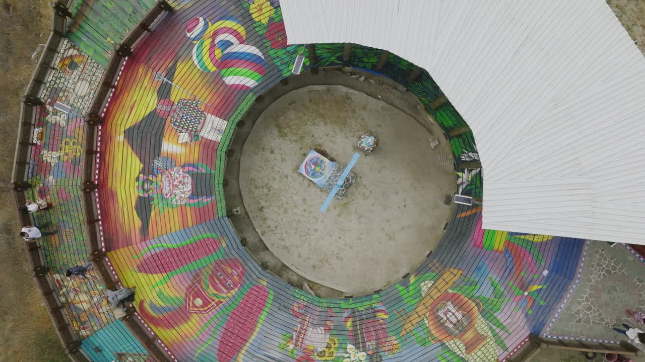 imágenes aéreas giratorias de arriba hacia abajo del mirador kiaq'aiswaan, plataforma de observación de san juan la laguna que muestra arte tradicional guatemalteco