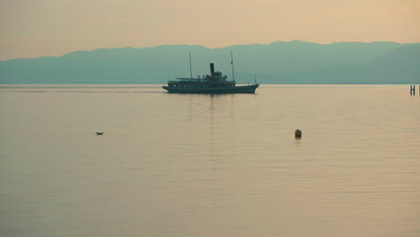 silhouette of ferry in lake geneve during sunset between france and switzerland