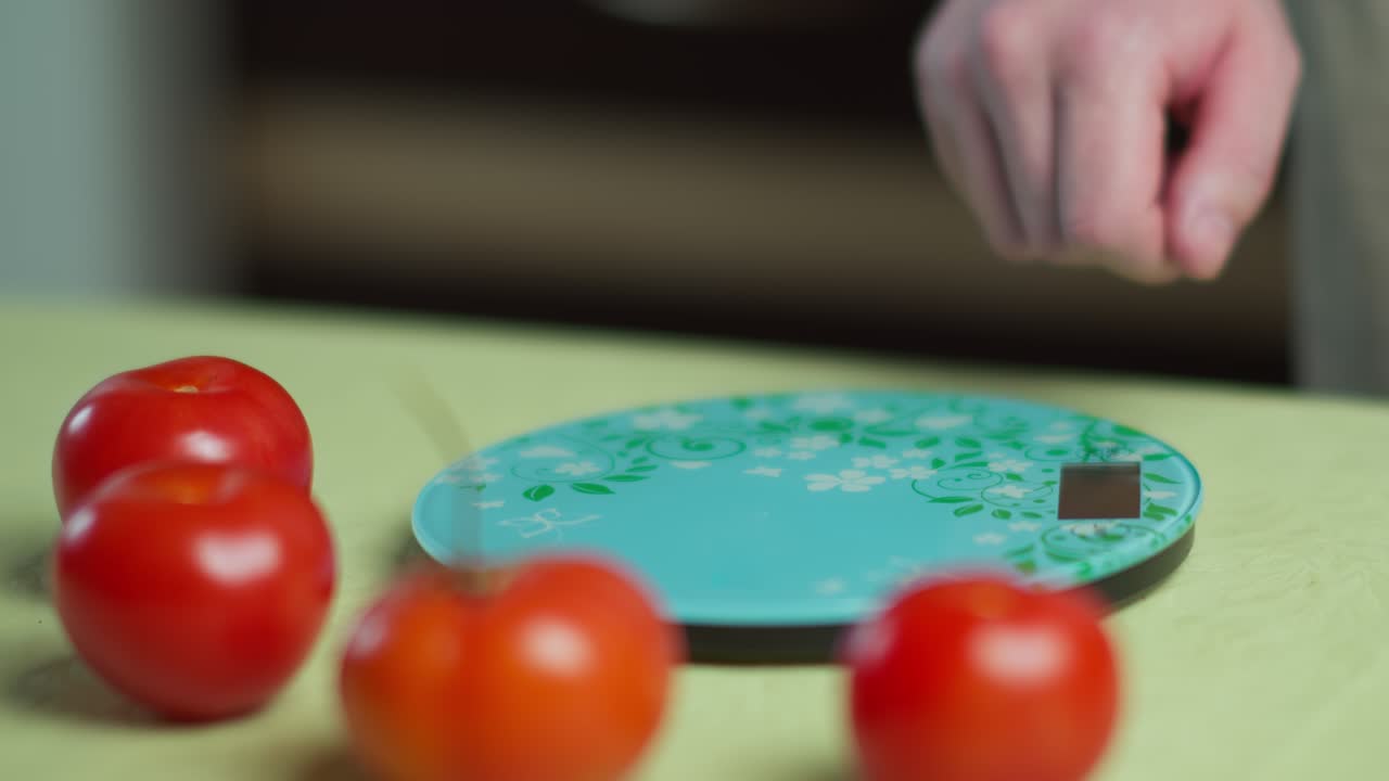 주방 전자 척도 에서 신선 한 토마토 를 무게 로 측정 하는 사람, 클로즈업