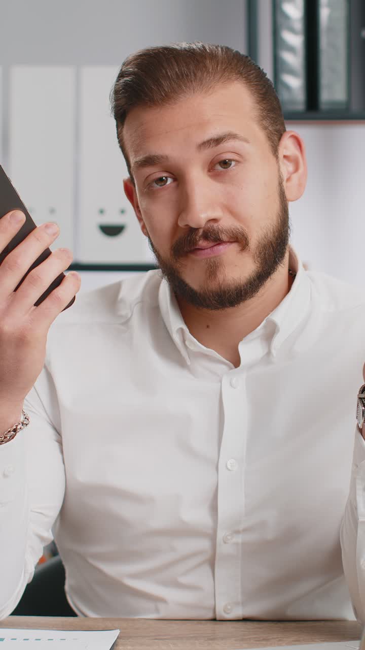 Uomo d'affari che mostra lo smartphone che gioisce sinceramente di vincere ricevendo denaro dollari banconote in contanti