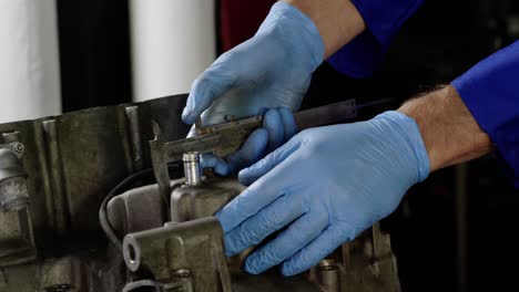 male mechanic repairing motorbike engine in repair garage 4k