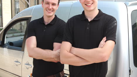 Two-young-tradesmen-posing-by-their-van