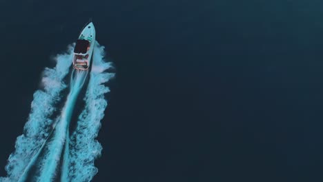 aerial shot of a luxury speed boat riding on the ocean at sunset