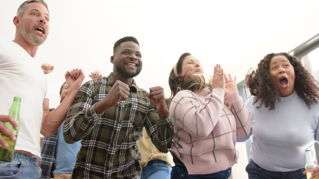 amigos varones y mujeres felices viendo deportes en la televisión y celebrando la victoria.