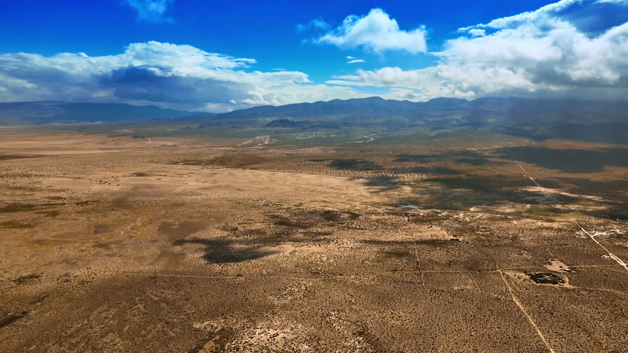 Amazing scenery of a desert in California. Dry lifeless landscape of Death Valley under the azure sky with white clouds. Top view.