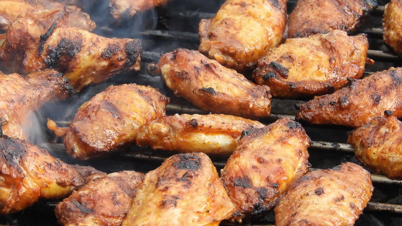 Outdoor grill with chicken wings, pork and fish under the heat of flames and smoke with nice texture and appetizing look.
