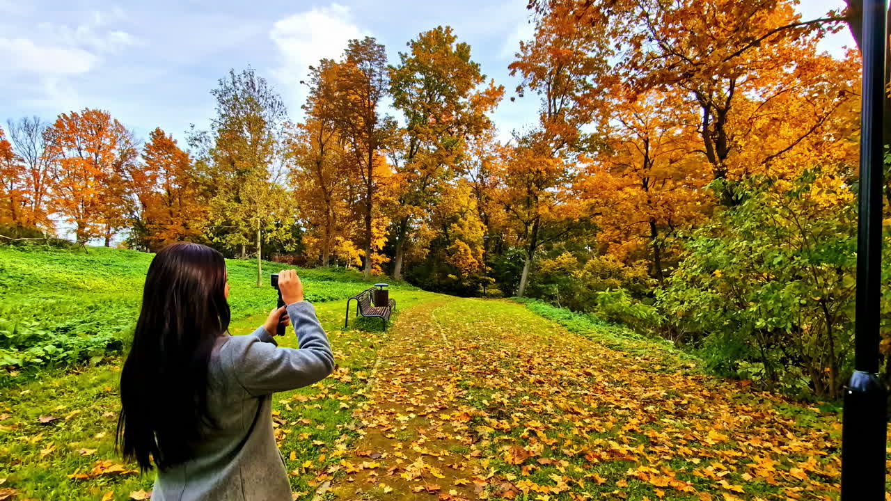 Autumn in the Park: A Woman Captures the Golden Foliage