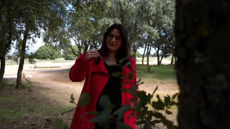 Donna che cammina in campagna mostra improvvisamente un'ecografia di gravidanza alla telecamera.