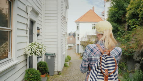 A-Woman-Walks-Along-The-Narrow-Street-Of-The-Old-City-Uses-A-Navigator-On-A-Smartphone-The-City-Of-B