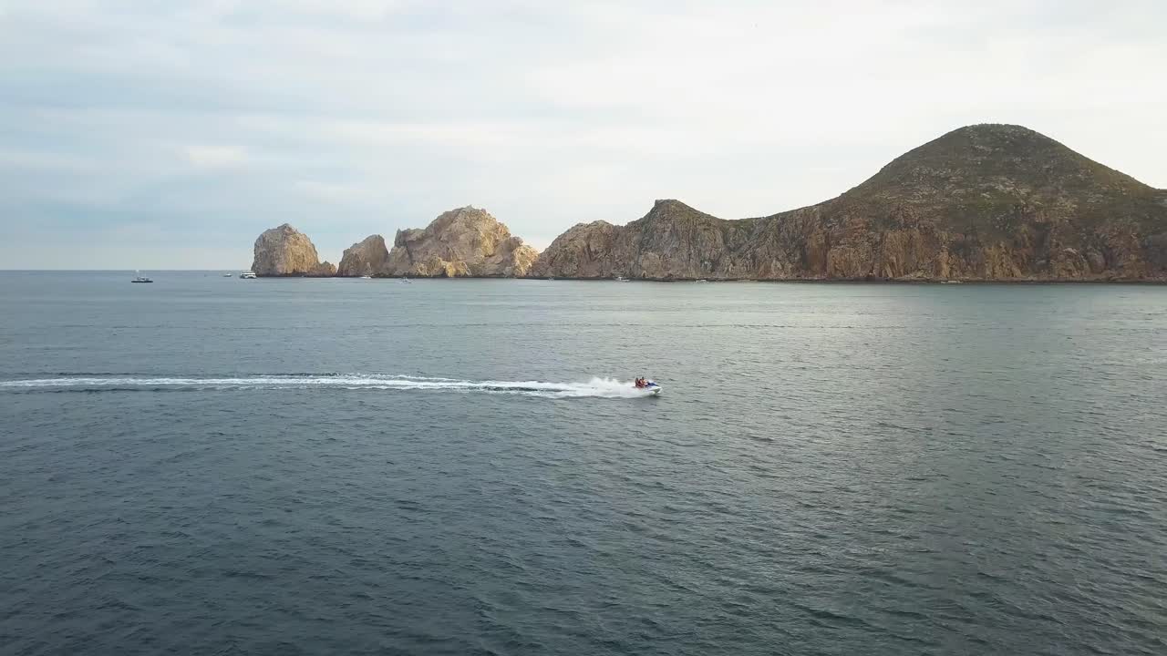 vista panorámica de las hermosas colinas rocosas del famoso arco en el fondo y una rápida moto de agua que lo cruza