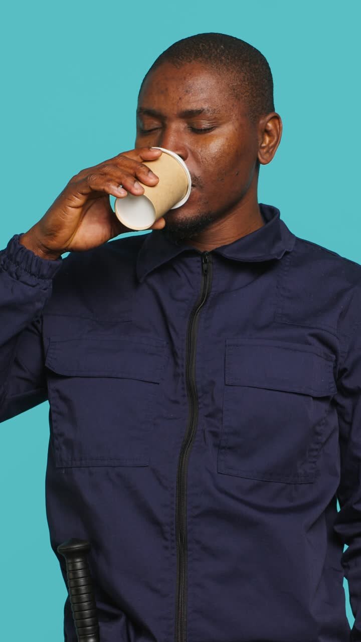 Uomo afroamericano stanco che sbadiglia e beve caffè