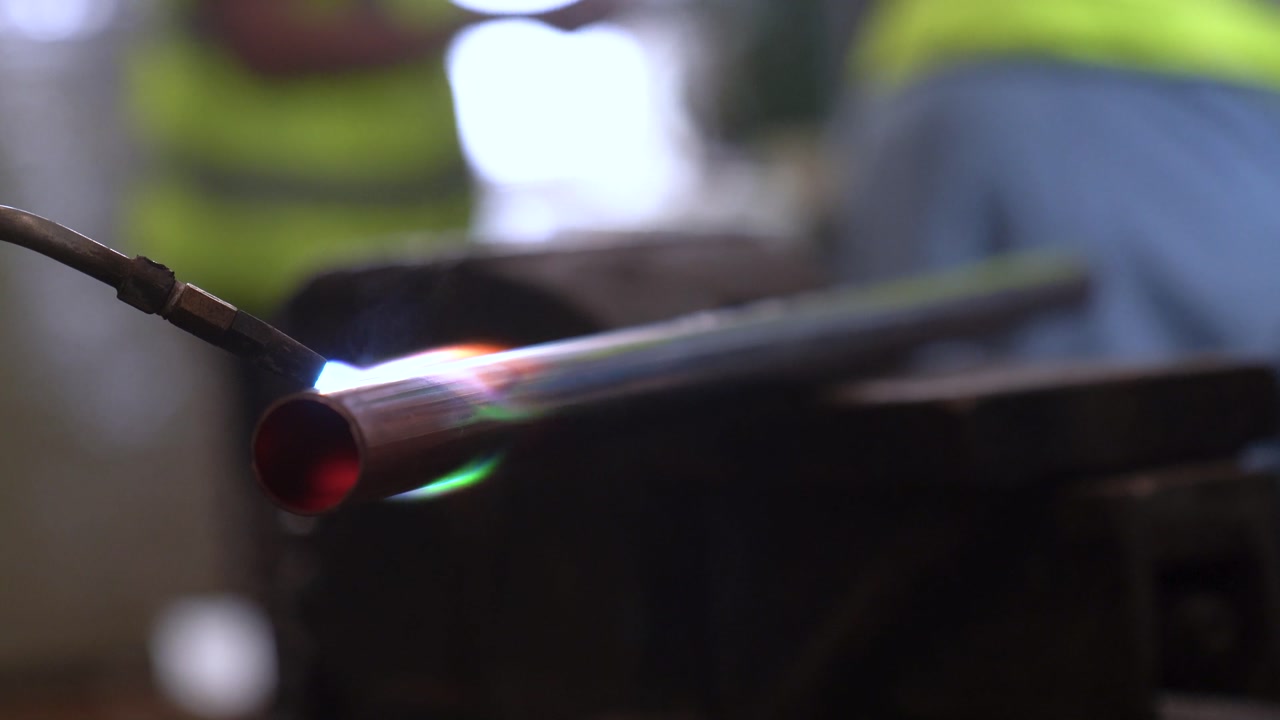Copper Pipe Being Heated Up With A Blow Torch During Assembly In A Industrial Metal Manufacturing Plant.
