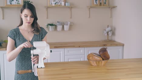 lady fixes handle on domestic flour mill at kitchen table