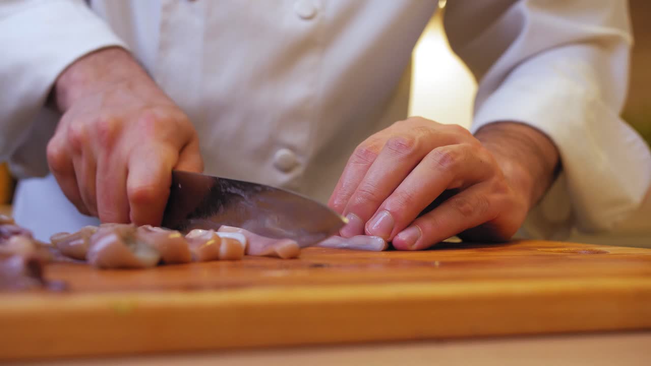 요리사는 나무 판자에 오징어를 자른다