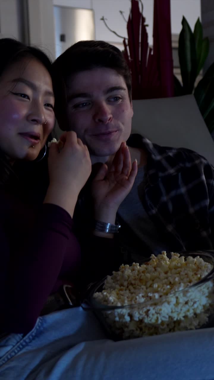 Casal assistindo TV e comendo pipoca