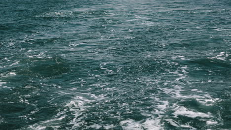 a high angle shot of a body of water from the stern of a moving boat