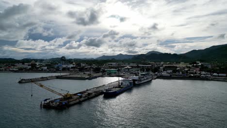 establishing overhead drone shot of a philippine port with docked ferry boats and a dockside crane